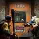 Four people stand outside a barricaded door holding weapons in Back 4 Blood.